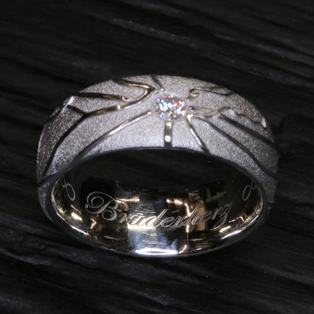 Platinring mit mittigem Erinnerungsdiamant, strahlenfoermiger RetinaSignatur und Innengravur Bruderherz, handgefertigt bei RetinaDesign in Basel
