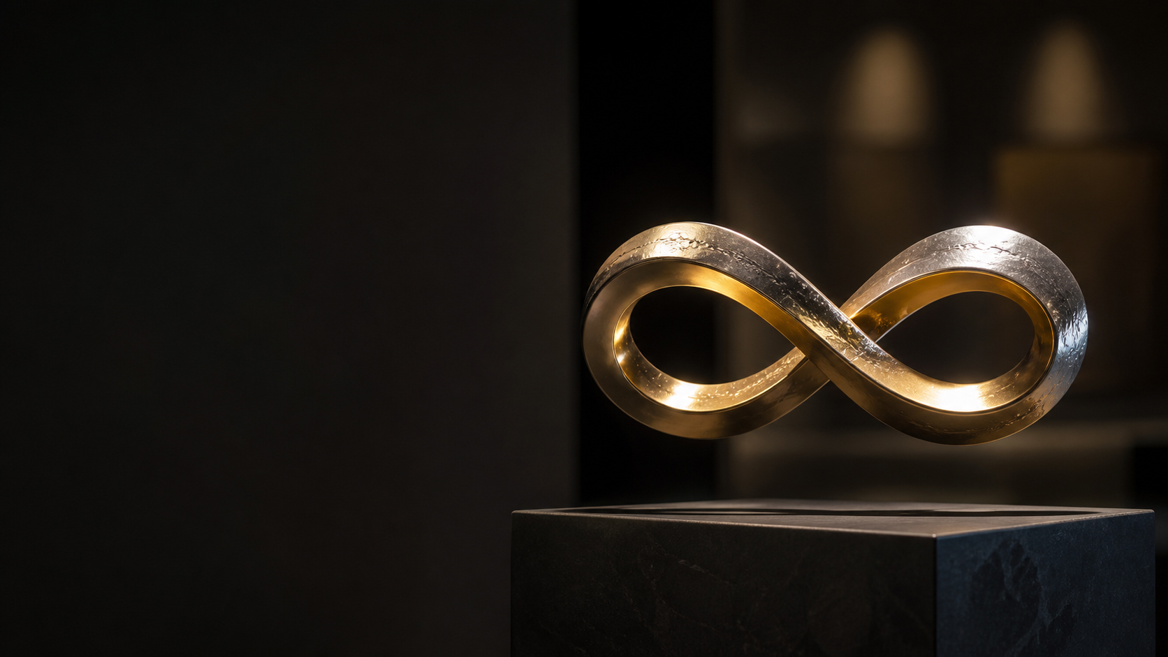Unendlichkeitszeichen als Symbol für ewige Verbundenheit und Liebe – goldenes Möbiusband auf Steinsockel